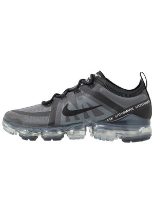 Black and gray Nike Vapormax sneakers feature a breathable mesh upper, transparent air cushioning sole, and prominent brand logo accents.
