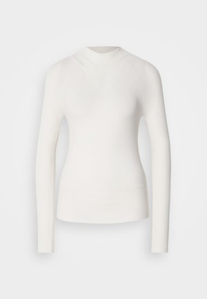 Hvit langermet topp med høy hals, ribbet tekstur og tettsittende design. Har et sømløst utseende og en subtil V-form foran.