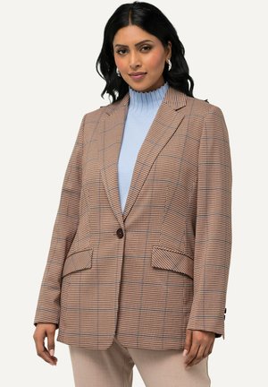 Hnědý kostkovaný blazer se strukturovaným designem, dvěma předními kapsami a hnědým knoflíkem. Nosený přes světle modrý žebrovaný rolák.