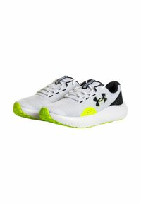 Zapatillas deportivas blancas con parte superior de malla, acentos negros y suela verde brillante. Cuentan con cordones y pequeños orificios de ventilación para transpirabilidad.