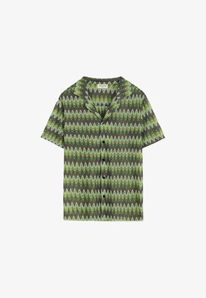 Chemise à manches courtes avec un motif zigzag en tons de vert, marron et bleu. Dotée d'un col en V et d'une fermeture à boutons sur le devant. Tissu léger.