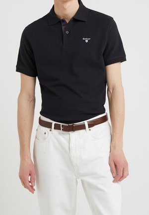 Zwarte poloshirt met een klassieke kraag, korte mouwen en een subtiele geborduurde logo, gecombineerd met witte jeans en een brown riem.