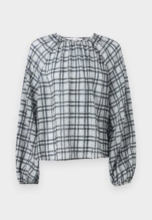 Blouse à carreaux en tissu léger, avec un col rond, de longues manches bouffantes et un devant froncé. Les couleurs incluent le gris et le noir.
