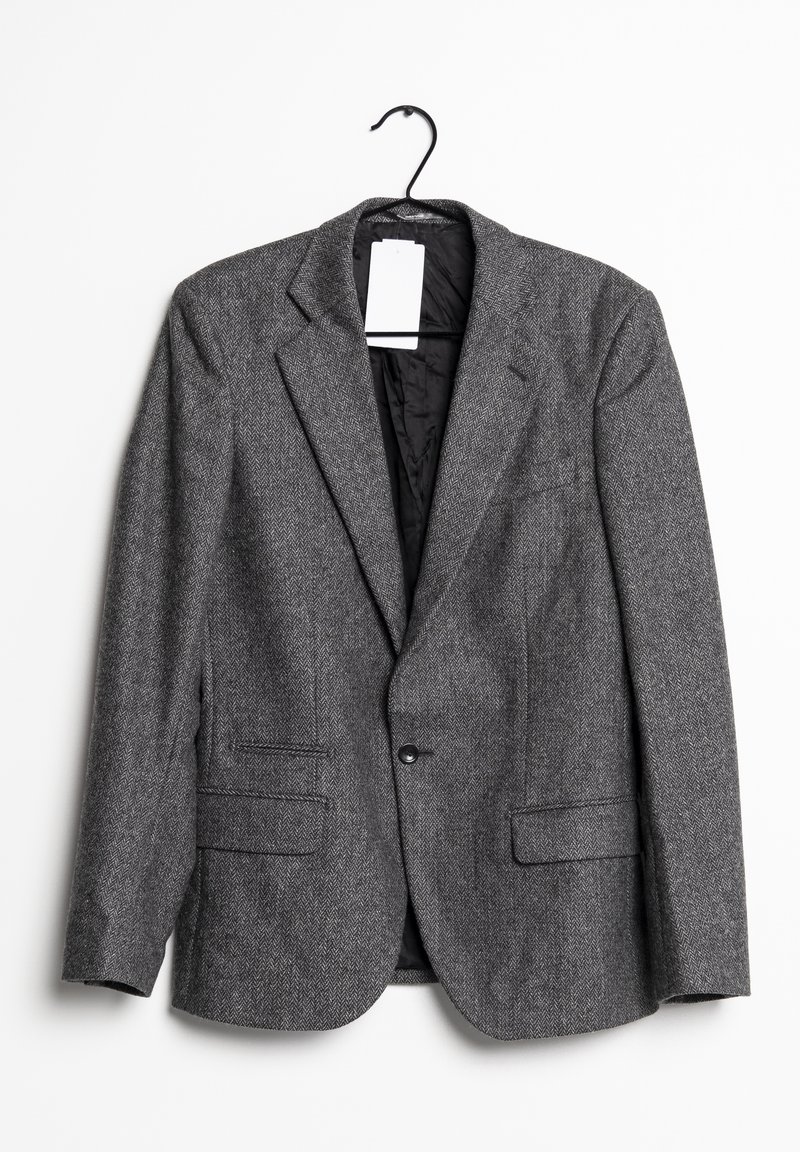 Grå herringbone-blazer på en galge, med en enkel knappstängning, två framfickor och en mjuk svart foder.