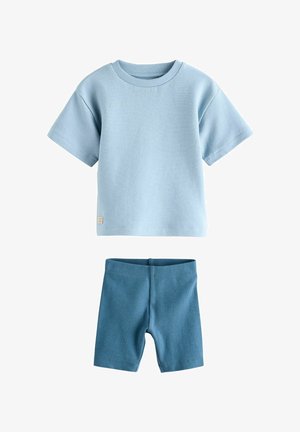 Light blue ribbed short-sleeve shirt with wide neckline paired with matching ribbed cycling shorts in a slightly darker blue.