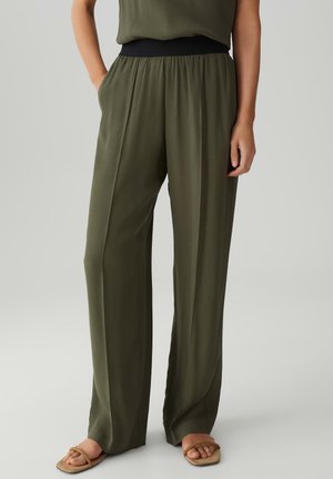Olive green wide-leg trousers with a black elastic waistband, featuring smooth fabric and soft texture, suitable for casual or semi-formal wear.