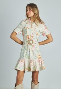 Blumengemusterte Kleid aus leichtem Material, mit tailliertem Gürtel, kurzen Ärmeln und ausgestelltem Saum. Die Farben umfassen Rosa, Grün und Orange.