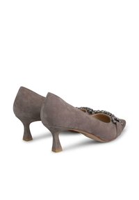 Zapatos de ante gris de tacón bajo con punta redonda y acentos decorativos de cuentas en la parte delantera. El tacón mide aproximadamente cinco centímetros de altura.