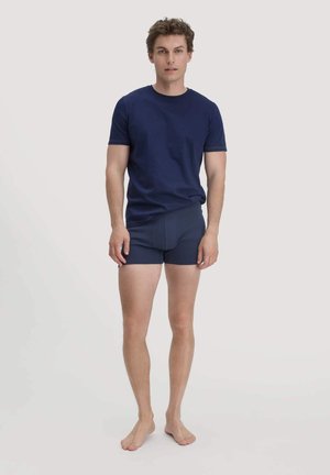 Navyblaue Baumwoll-T-Shirt mit kurzen Ärmeln, kombiniert mit passenden, körperbetonten Boxerbriefs, die eine glatte Textur und ein minimalistisches Design aufweisen.