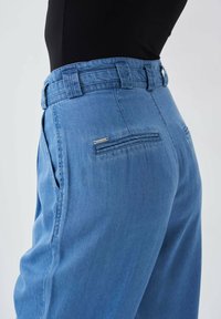 Pantalones de mezclilla azul claro con una cintura alta, bolsillos laterales y dos bolsillos traseros con un diseño de costura horizontal. Textura suave.