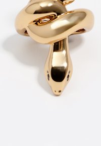 Broche en forma de serpiente en tono dorado con un acabado pulido, que presenta una textura suave y ojos detallados, enfatizando las curvas y un diseño elegante.