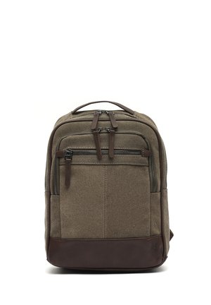 Brown canvas and leather backpack with multiple zippered compartments and a top carry handle, standing upright on a white background.
