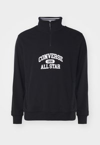 Zwarte zip-up sweatshirt met een hoge kraag, geribde manchetten en een witte "Converse All Star 1908" logo in het midden. Zachte stof textuur.