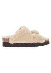 Chausson beige avec une texture douce et moelleuse, équipé de deux sangles et d'une semelle en caoutchouc marron foncé. Design simple et moulé de la semelle pour un confort optimal.