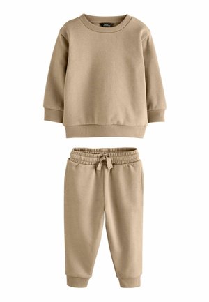 Beige Baumwollpullover mit rundem Halsausschnitt und gerippten Bündchen, kombiniert mit passenden elasticisierten Hosen mit Kordelzug und umschlägen.