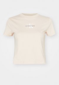 Maglietta a maniche corte cropped beige con collo a giro e logo "Calvin Klein Jeans" al centro davanti.