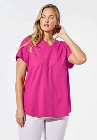 Fuchsia-pinkes V-Ausschnitt-T-Shirt mit kurzen Ärmeln, aus weicher Baumwolle. Lockerer Schnitt mit glatter Textur und minimalen Nähten.