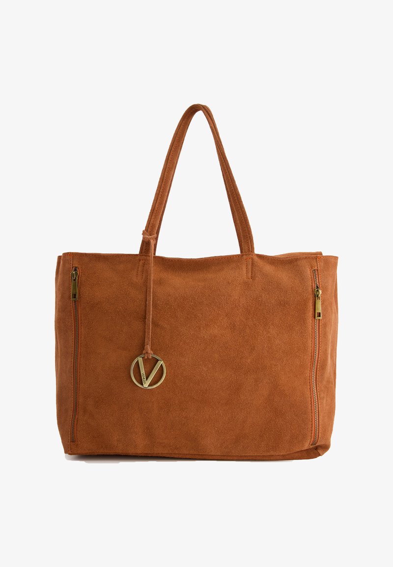 Brązowa torebka zamszowa z dwiema kieszeniami na zamek, długimi uchwytami i złotym okrągłym logo przymocowanym skórzanym paskiem.