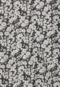 Tissu noir avec un motif dense de petites fleurs blanches uniformément réparties sur la surface.