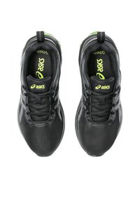 Scarpe sportive nere con tomaia in mesh testurizzato, con accenti verdi, stringhe e strisce riflettenti sui lati.