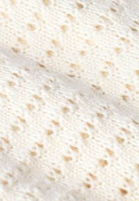 Strickstoff in Cremefarbe mit einem offenen, spitzenähnlichen Muster, das kleine Diamantformen enthält. Weiche Textur mit einem gemütlichen Erscheinungsbild.