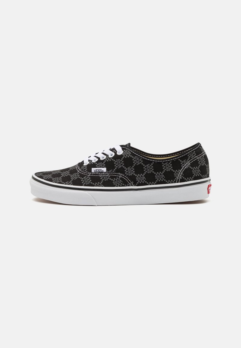 Baskets Vans noires avec lacets blancs, semelle blanche et motif à damier avec le texte "VANS" imprimé sur tout le tissu.