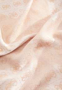 Tkanina w delikatnym brzoskwiniowym kolorze, charakteryzująca się subtelną fakturą tkacką z nakładającym się wzorem lekkich motywów oraz gładkim połyskiem.
