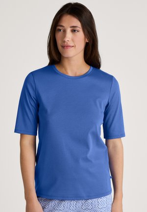 Blauwe t-shirt met korte mouwen, gemaakt van zachte stof, met een ronde halslijn en een gladde textuur, gecombineerd met een patroonrok of -broek.