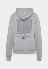 Grå hoodie med dragskohet. Funktioner en svart, horisontell linjegrafik och textlogotyp på baksidan. Mjuk kvalitet, ribbad mudd och nederkant.