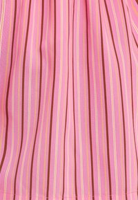 Tissu rayé avec des lignes verticales dans des teintes de rose, orange et marron. Texture lisse avec une apparence légère et fluide.