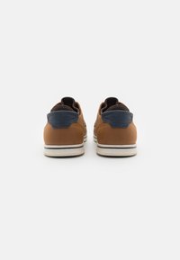 Pantofi din piele maro cu accent pe toc albastru marin, talpa din cauciuc crem, design elegant și finisaj texturat la spate.