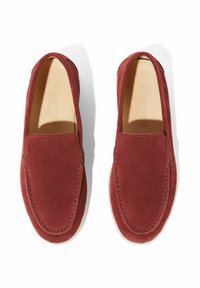 Mocasines de ante en rojo profundo con un diseño de fácil calce, que presentan costuras tonales y una plantilla de cuero suave, exhibidos desde arriba sobre un fondo blanco.