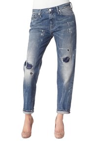 Modré džínové kalhoty s poškozenými detaily, viditelnými dírami a uvolněným střihem. Obsahuje stočený lem a design s pěti kapsami. Vyblitý vzor.