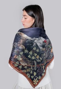 Foulard en soie avec un fond bleu foncé, présentant des images détaillées de la nature, y compris un ours, des fleurs et des motifs feuillus, encadré par une bordure marron.