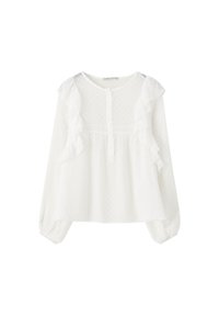Blouse blanche à manches longues avec volants sur les côtés avant, motif à pois texturé, encolure ronde et fermeture boutonnée.