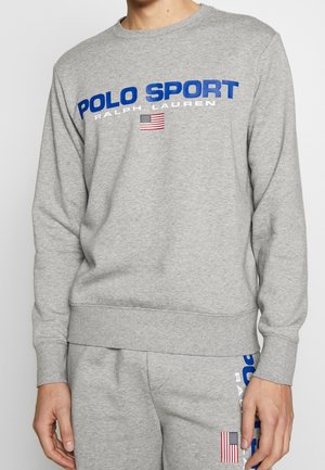 Ensemble sweat-shirt et pantalon de survêtement gris avec le texte « Polo Sport Ralph Lauren » et de petits logos du drapeau américain sur la poitrine et la jambe.