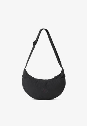 Schwarze Umhängetasche mit einem geschwungenen, gepolsterten Design. Verfügt über zwei kreisförmige Akzente (einen schwarzen, einen roten) und einen verstellbaren Tragegurt. Reißverschlussverschluss.