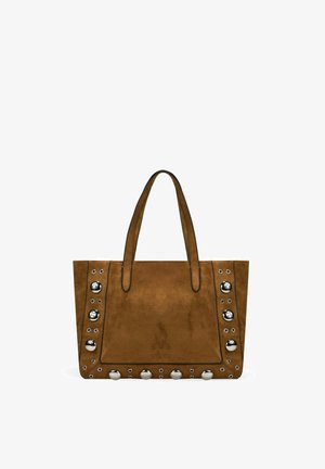 Bolso tote de ante marrón con dos asas, decorado con tachuelas plateadas grandes y pequeñas a lo largo de los bordes frontales y la parte inferior.