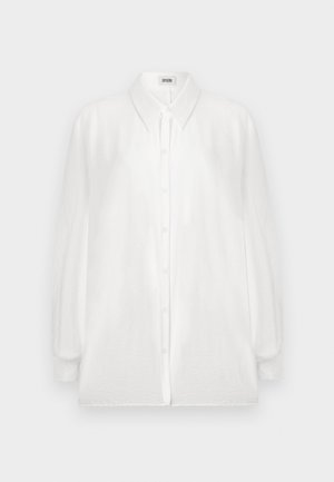 Valkoinen nappikauluspaita, joka on valmistettu kevyestä kankaasta. Paidassa on pitkät hihat, klassinen kaulus ja hieman löysä istuvuus.