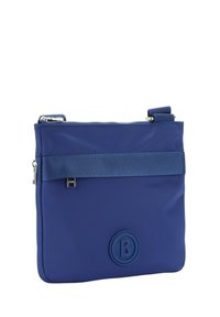 Borsa in nylon blu con chiusura a zip, caratterizzata da una fascia in tessuto testurizzato e un logo rotondo. Forma rettangolare compatta, superficie liscia e tracolla regolabile.