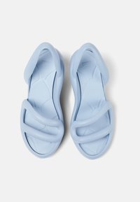 Light blue rubber sandals with a molded design, featuring two wide straps across the foot and a textured sole for grip.
