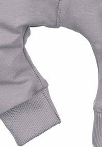 Szara bluzka z długim rękawem, posiadająca ściągacz na mankietach, gładką fakturę oraz podwójne szwy zapewniające trwałość, z kątem cięcia przy ramieniu.