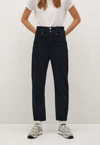 High-waisted, dark blue denim pants with a relaxed fit, featuring two front pockets, a button fly, and a gathered waistband detail.