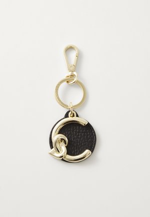 Porte-clés en cuir noir avec un disque rond texturé. Doté d'un fermoir en métal doré et d'une boucle, avec un accent doré entrelacé sur le disque.