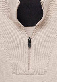 Beige quarter-zip sweater with ribbed texture, featuring a black zipper pull, and a contrast inner collar in solid black.