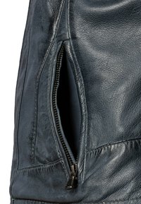 Donkerblauwe leren jas met een zijritszak, een gestructureerd oppervlak en gestikte details langs de naden.