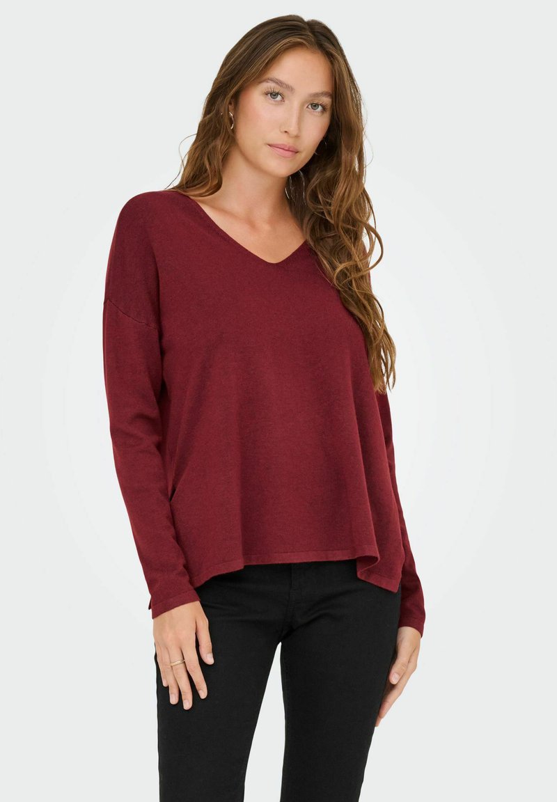 Pullover borgogna a maniche lunghe con scollatura a V, vestibilità comoda e polsini a costine. Realizzato in un tessuto morbido, presenta una finitura testurizzata.