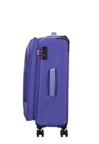 Valigia rigida viola con superficie testurizzata, doppie cerniere, maniglia laterale e quattro ruote nere per stabilità e manovrabilità.