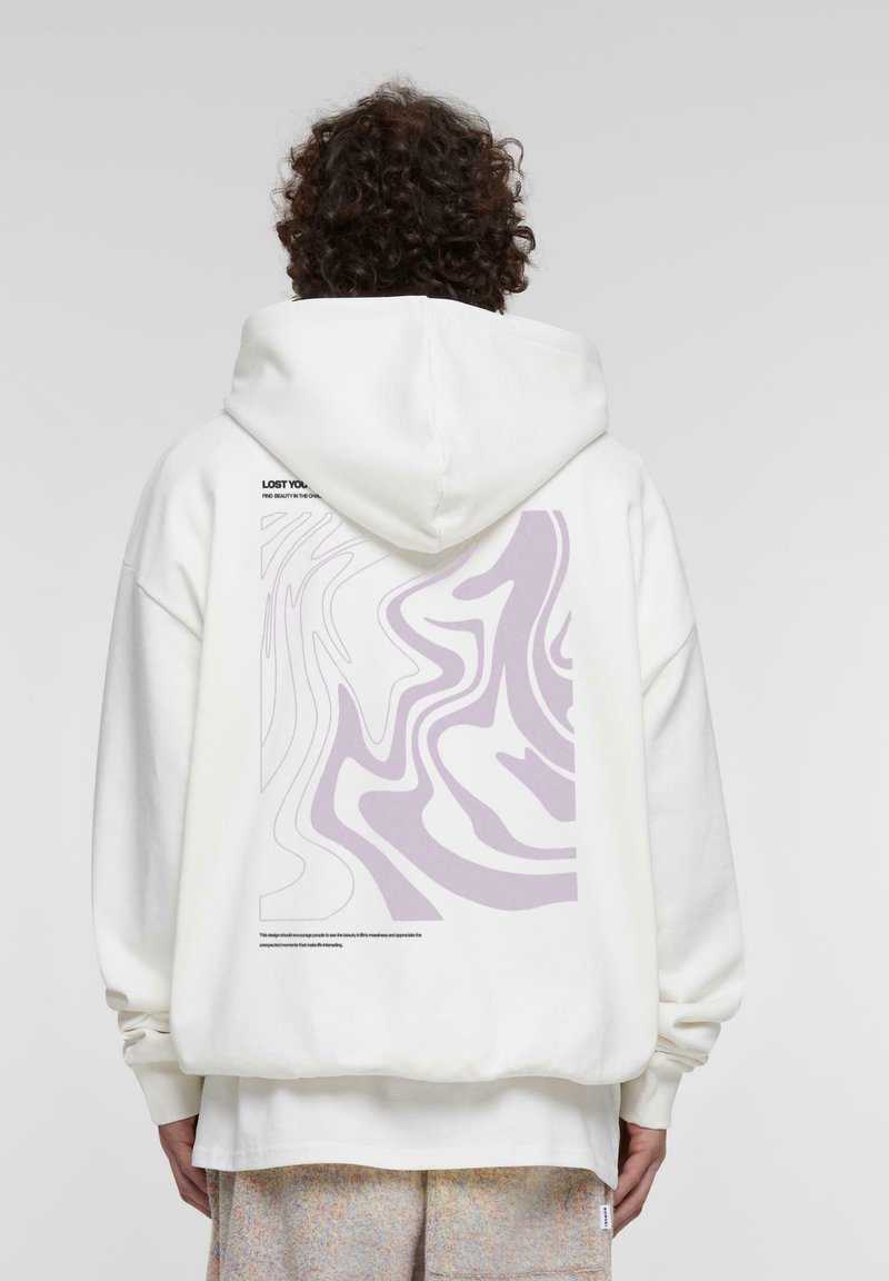 Felpa bianca con un grande design astratto viola sul retro, con testo nella parte superiore. Tessuto morbido con una vestibilità comoda e cappuccio.