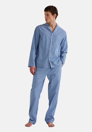 Ensemble de pyjama en coton rayé bleu et blanc comprenant une chemise à boutons à manches longues et un pantalon à taille élastique. Il dispose d'une poche poitrine.